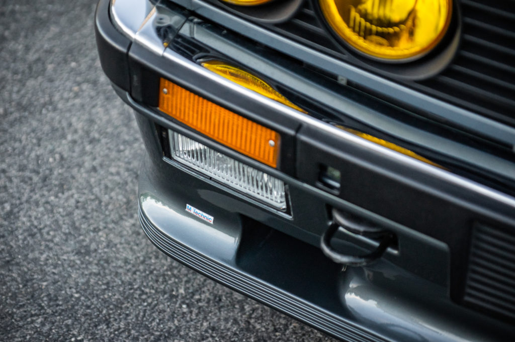 Sleek black bwm e30 coupe with detailed front grill on a foggy